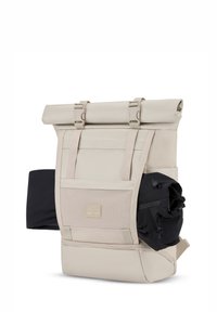 Világos bézs roll-top hátizsák texturált elülső zsebbel és fekete oldalzsebbel. Állítható pántokkal és műanyag kiegészítőkkel rendelkezik.