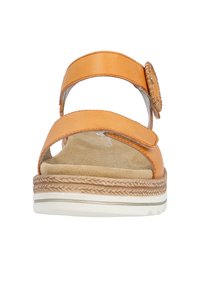 Sandale orange avec deux larges brides, l'une ornée d'un bouton décoratif, et une semelle intérieure rembourrée sur une semelle texturée.