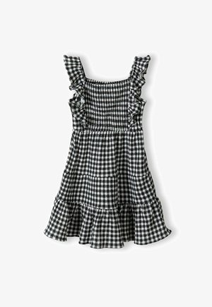 Czarna i biała sukienka w kratę vichy z falbankowymi ramiączkami, marszczonym gorsetem i rozkloszowaną spódnicą z kaskadowym dołem.