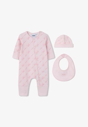 Une combinaison en coton rose avec des manches longues, fermeture à pression, et un motif d'ours ; comprend un chapeau et un bavoir assortis, tous présentant des accents de marque.