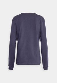 Dlouhý rukáv tmavě modré tričko vyrobené z měkké tkaniny, s kulatým výstřihem a přiléhavými rukávy. Jednoduchý design bez viditelných vzorů.