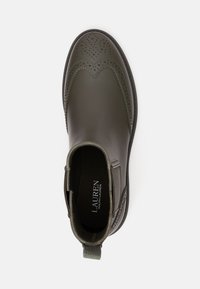 Bota Chelsea de pele verde escura com detalhes brogue, acabamentos texturizados, bico arredondado e uma alça no calcanhar para facilitar o calçar.