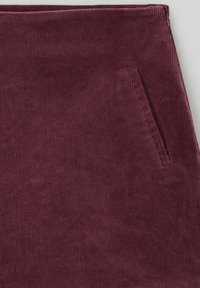 Jupe en velours côtelé bordeaux avec une texture côtelée verticale et une poche latérale. Finition lisse avec une coupe ajustée.