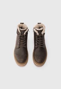 Brune læderankle støvler med snørelukning, kunstpelsforing og en robust gummisål. Har sølv hardware og beige stikninger.