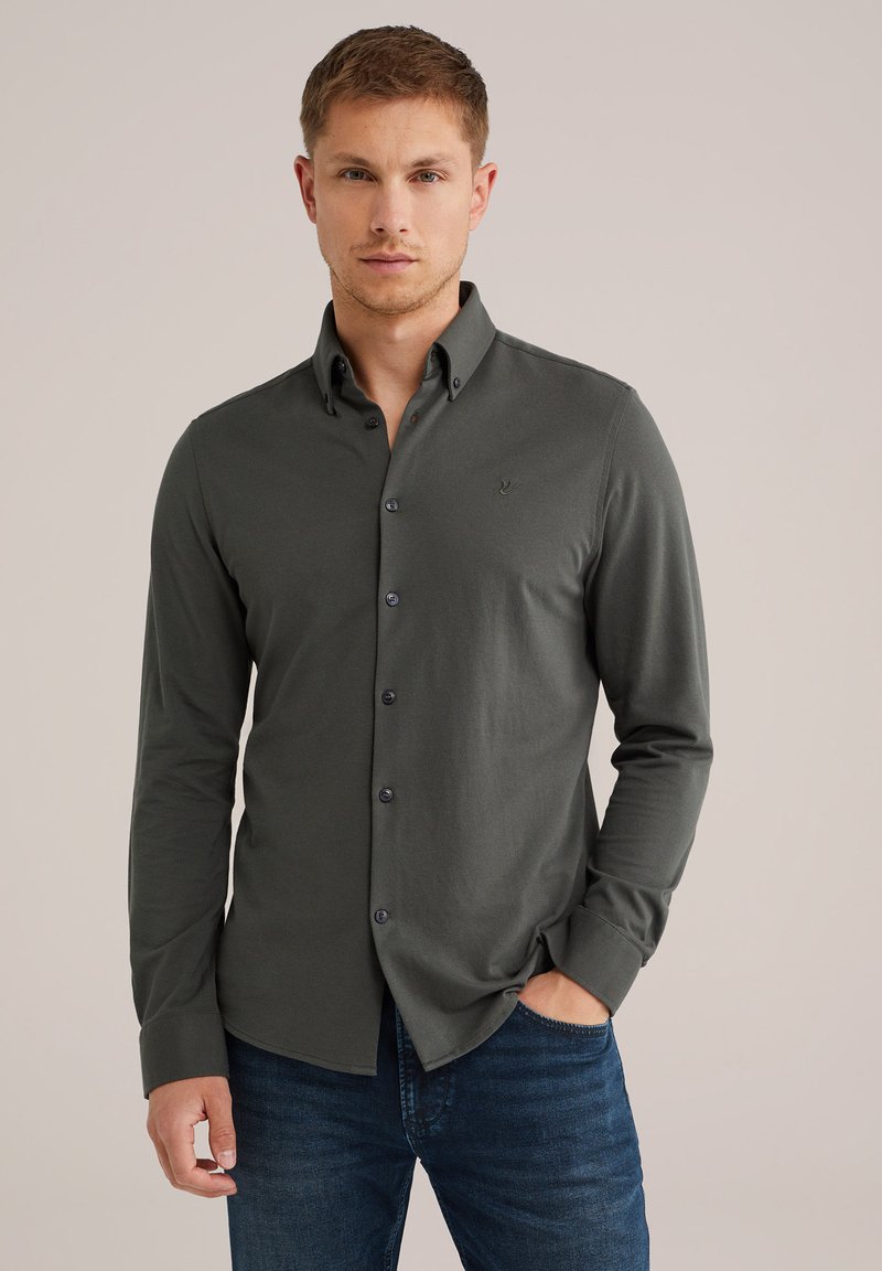 Camisa de botones verde oscuro hecha de una suave mezcla de algodón, con cuello, mangas largas y un sutil logo bordado en el pecho.