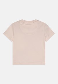 Różowa, krótka koszulka z miękkiej bawełny. Posiada okrągły dekolt i proste przeszycia. Brak wzorów lub grafik.