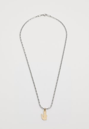 Collier en argent avec un pendentif en or en forme de main. La chaîne présente des maillons allongés, ajoutant de la texture au design.