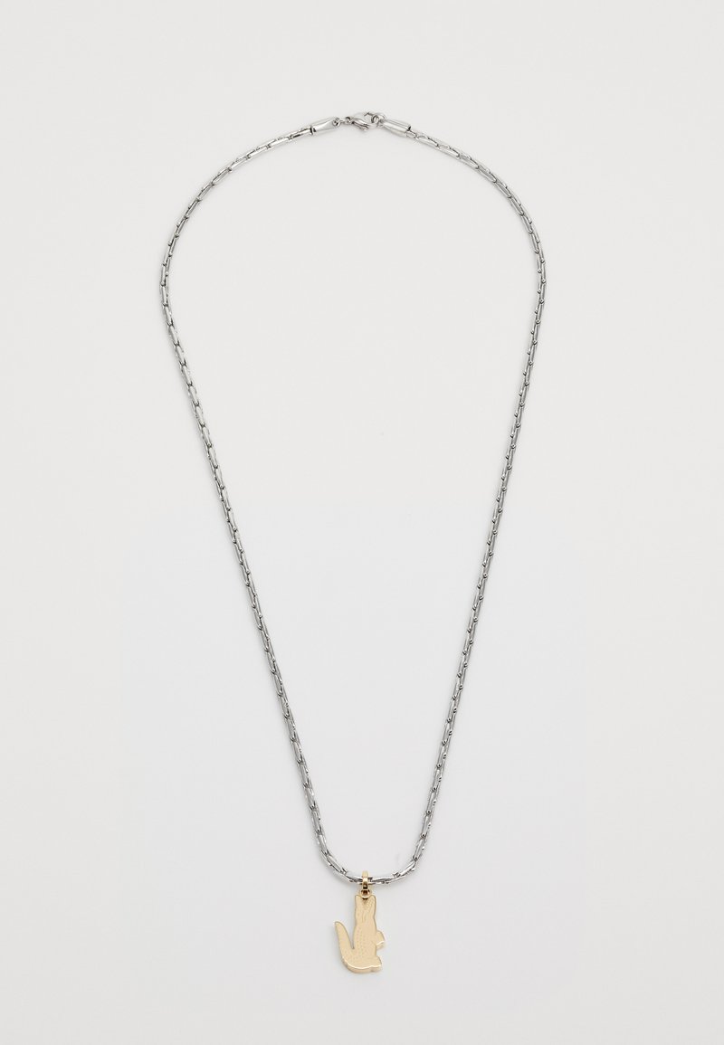 Ασημένια αλυσίδα λαιμού με χρυσό κρεμαστό διακοσμητικό σε σχήμα χεριού. Η αλυσίδα έχει επιμηκυμένα κρίκους, προσέχοντας την υφή του σχεδίου.