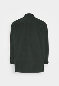 Camisa de manga larga verde oscuro, fabricada en algodón suave. Tiene un cuello estándar, puños abotonados y una textura lisa sin patrones visibles.