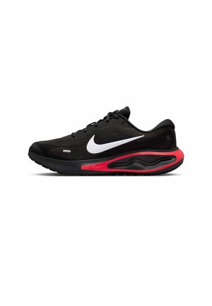Schwarzer Nike Laufschuh mit weißem Swoosh-Logo und rotem Dämpfungsdetail an der Zwischensohle, seitlich auf weißem Hintergrund gezeigt.