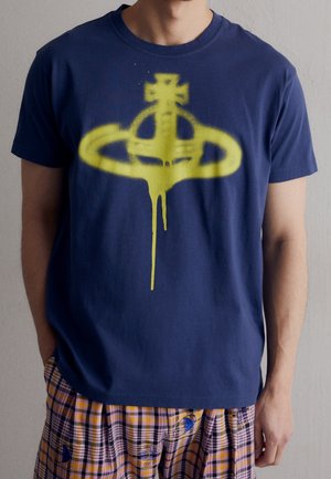 Mørkeblå bomulds T-shirt med et stort gult spraymalet logo-design på forsiden. Rund halsudskæring og korte ærmer.