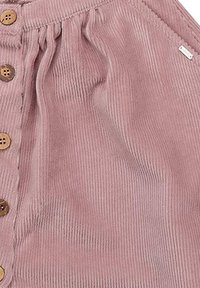 Rosa Corduroykleid mit Knopfverschluss, ausgestattet mit vertikalen Rippungen und raffiniertem Detail an der Taille. Enthält ein kleines Markenzeichen.