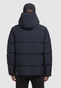 Granatowa kurtka puchowa z dużym, wyściełanym kapturem, ściągaczami na rękawach i przeszyciem u dołu. Materiał wydaje się gładki i ocieplony.