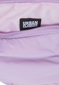 Borsetta in tessuto lilla con chiusura a zip. All'interno presenta un'etichetta in tessuto con la scritta "URBAN CLASSICS" in carattere bianco su sfondo nero.