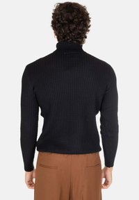 Maglione nero lavorato a maglia con collo alto, texture a coste e maniche lunghe. La vista posteriore mostra un design aderente senza decorazioni.