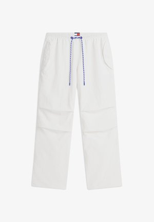 Pantalon décontracté blanc avec taille élastique, cordon bleu et blanc, poches latérales et petite étiquette logo rectangulaire au centre de la taille.
