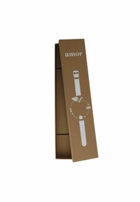 Ein Karton mit der Aufschrift "amor" enthält ein minimalistisches Uhrendesign mit einer Apfelgrafik, das eine Verbindung zum Wohlbefinden verdeutlicht.