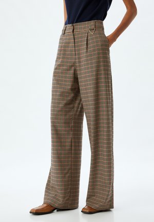 Pantalons larges à motif à carreaux dans des teintes de brun, orange et noir. Design taille haute avec plis et texture de tissu lisse.