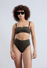 Svart bikini-sett med en strukturert topp med tynne stropper og høymidje-bunn, prydet med et blomstermønster i dempede farger.