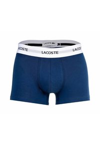 Granatowe bokserki wykonane z mieszanki bawełny. Posiadają białą, markową gumę w pasie z logo "Lacoste" oraz dopasowany krój.