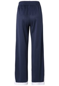Pantaloni ampi a righe navy con cintura elasticizzata e dettagli bianchi all'orlo. Realizzati in un tessuto liscio, presentano una finitura pulita.