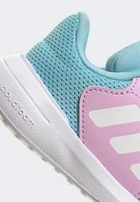 Jasnoniebieski tenisówka z siateczki z różowymi skórzanymi akcentami i białymi paskami logo. Posiada teksturowaną podeszwę i wyściełany kołnierz dla wsparcia.