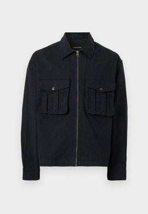 Must must kinnituseta jakk, millel on kaks suurt eest taskut klappidega ja nuppudega, pikad varrukad ning terav krae, esitatud valgel taustal.