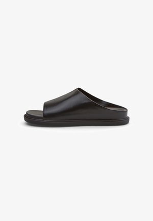 Schwarze Leder-Pantolette mit offenem Zehenbereich, breitem oberen Riemen und flacher Sohle, im Profil vor weißem Hintergrund dargestellt.