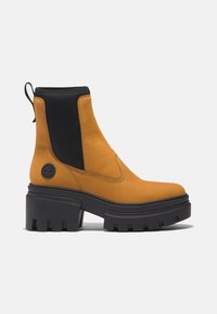 Chunky-Absatz-Ankle-Boots aus senfgelbem, glattem Leder mit schwarzen elastischen Seitenpaneelen und einer strukturierten schwarzen Gummisohle.
