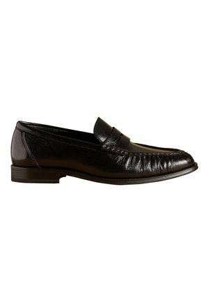 Black leather men's loafer with a low heel, moc toe stitching, and a strap across the upper.