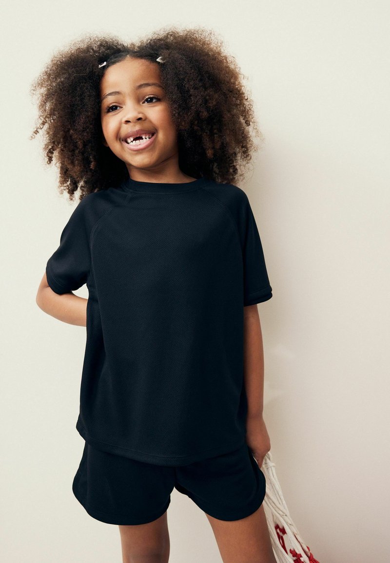 Zwarte sportshirt met korte mouwen en bijpassende shorts, gemaakt van ademend materiaal, met een relaxte pasvorm en ronde halslijn.
