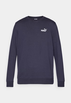 Námořnická modrá mikina s dlouhým rukávem vyrobená z bavlny. Obsahuje klasický kulatý výstřih, žebrované manžety a bílé logo PUMA na hrudi. Hladká textura.