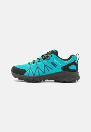 Chaussure de trail Columbia bleu clair et noire avec semelle robuste, empeigne en mesh, et parties renforcées au niveau des orteils et du talon.