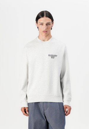 Sweatshirt grigio chiaro in morbido materiale, con collo rotondo e maniche lunghe. Presenta un logo scuro sull'area sinistra del petto.