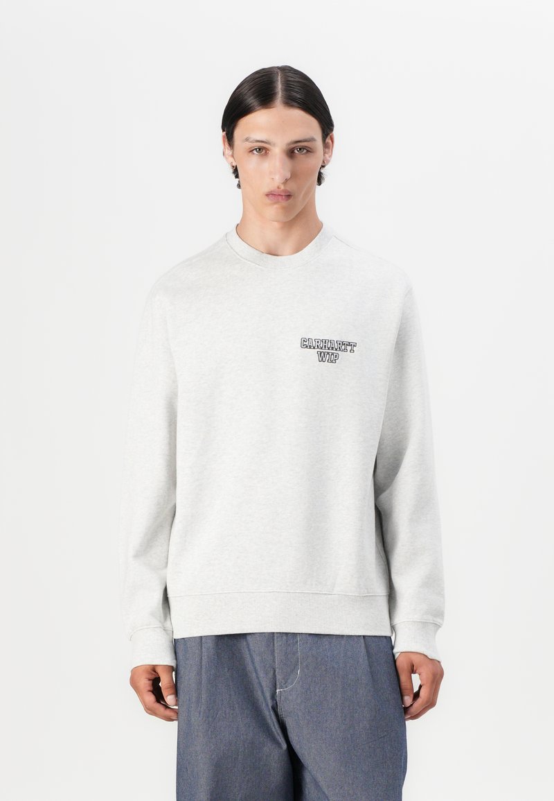 Lys grå sweatshirt lavet af blødt materiale, med rund hals og lange ærmer. Inkluderer et mørkt logo på venstre brystområde.
