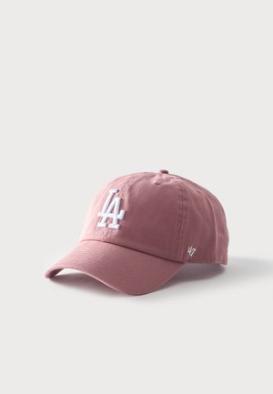 Gorra de béisbol rosa con el logotipo blanco de "LA" en el frente y un pequeño logotipo de "47" en el lado, colocada sobre una superficie gris clara.