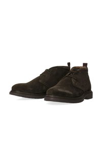 Stivali chukka in suede marrone con punta arrotondata, lacci in pelle e dettagli cuciti a contrasto, dotati di una suola in gomma bassa e un'etichetta per il comfort.