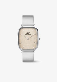 Reloj rectangular plateado con una esfera beige texturizada, marcadores blancos y una correa de malla plateada. Logo negro en la parte superior central. Diseño minimalista.