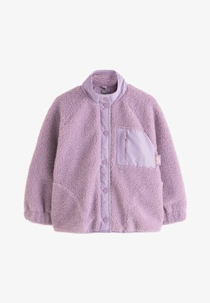 Világoslila polár dzseki patentos gombokkal, magas gallérral, elasztikus mandzsettákkal, illetve cipzáras mellzsebbel, elöl szövetcímkével.