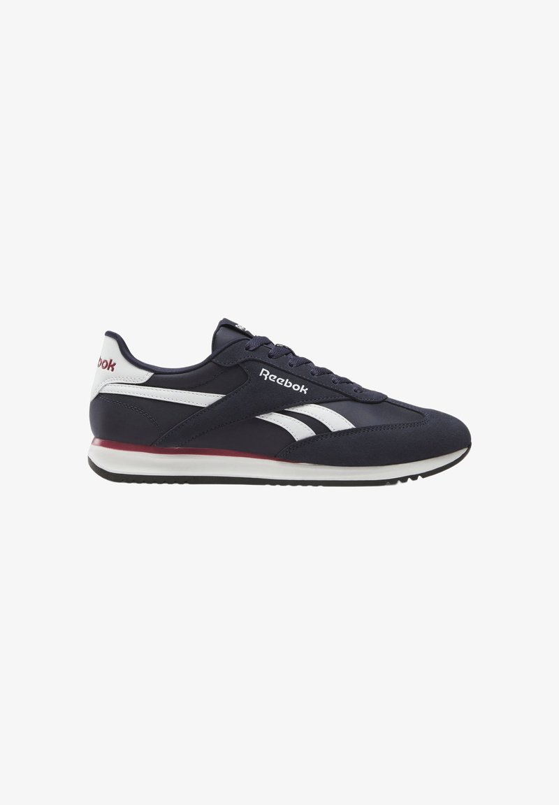 Navy blue and white Reebok low-top sneaker with white stripes, red accent on midsole, and lace-up closure.