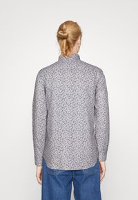 Lange mouwen shirt van lichte stof, voorzien van een bloemenpatroon in paarse en blauwe tinten met een mandarin-kraag en knopenmanchetten.