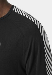 Zwart sportshirt van textuurstof met witte gestreepte accenten op de schouder en naadloze stiksel langs de halslijn.