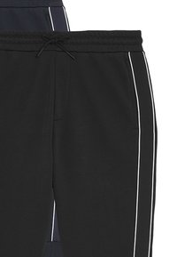 Zwarte sweatpants met witte zijkanten, een trekkoord in de tailleband en zijzakken. Gemaakt van zachte stof voor comfort.