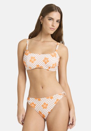 Zestaw bikini w kratkę w jasnym brzoskwiniowym i białym kolorze, z pomarańczowymi kwiatowymi wzorami. Górna część ma cienkie ramiączka i wyraźny kształt.