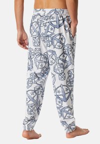 Weiße Schlafanzughose mit blauen grafischen Mustern, die Sterne und Kreise zeigen; elastischer Bund, seitliche Taschen, lockere Passform, Baumwollmaterial.