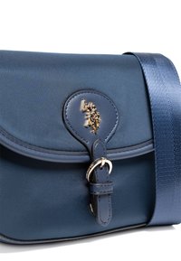 Borsa a tracolla in tessuto blu navy con finitura lucida, dotata di una chiusura e tracolla in metallo dorato, texture liscia e forma arrotondata.