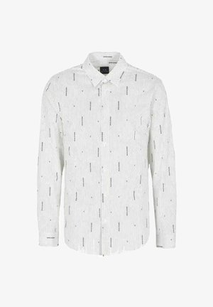 Camicia bianca a maniche lunghe con bottoni, decorata con sottili righe verticali e piccoli motivi testuali neri. Presenta un colletto classico e una tasca sul petto.