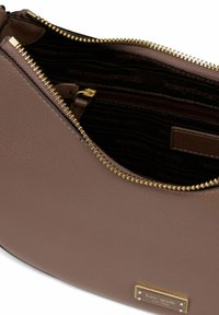 Borsa in pelle marrone con finitura testurizzata, dotata di una zip dorata e foderata all'interno con il nome del marchio in un motivo ripetuto.