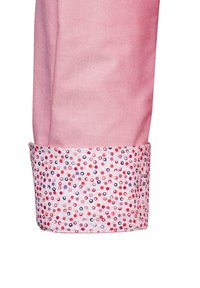 Rosa Stoffhemd mit einem gemusterten Bündchen, das kleine rote, rosa und lila Kreise enthält. Glatte Textur mit klassischem Schnitt.