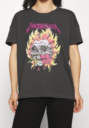 Dark grey t-shirt featuring a front graphic of a skull surrounded by flames, with pink and yellow accents, short sleeves, and a relaxed fit.